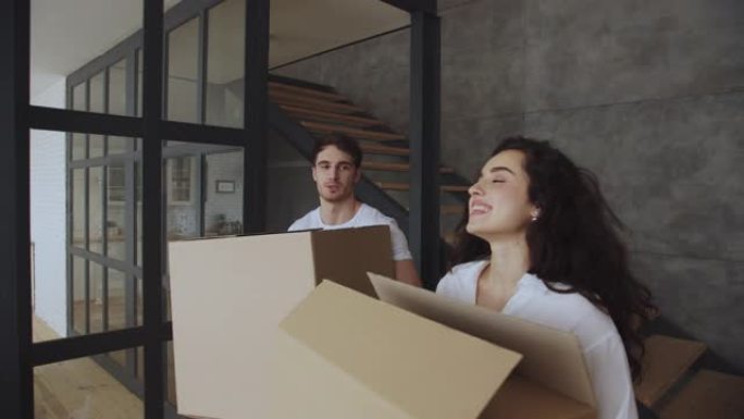 微笑的男人和女人在慢动作中关心纸盒。