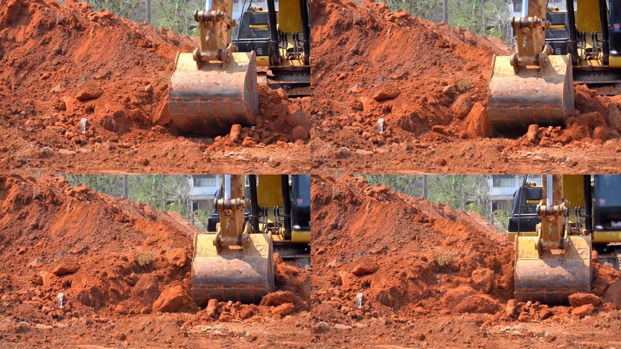 在阳光施工的情况下，挖掘机铲斗挖土的场景慢动作