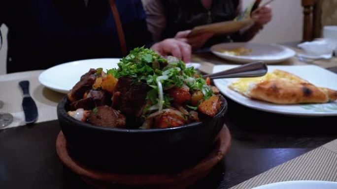 Ojahuri。格鲁吉亚餐厅的粘土锅中炸猪肉配土豆和香草