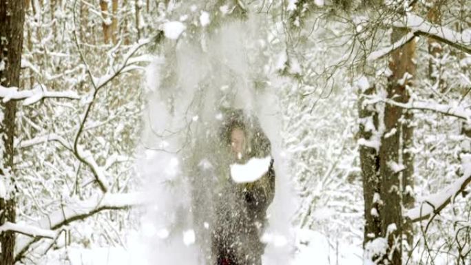 拉松雪树枝的女人。雪落在女孩的头上。慢动作。高清