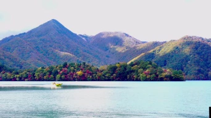 一艘快艇在中禅寺湖周围的山景