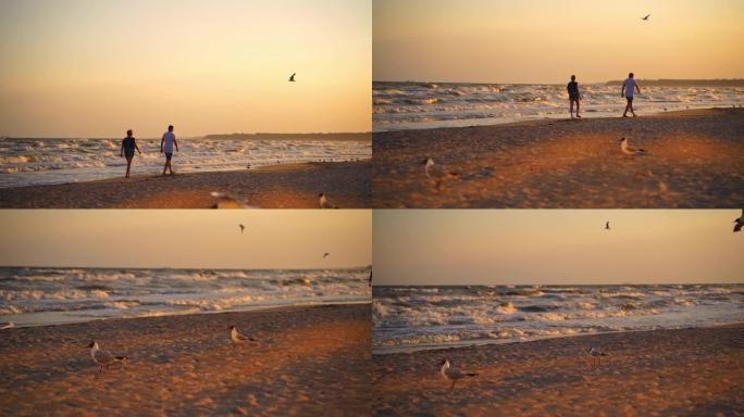 日落时走在海边的男人和女人。