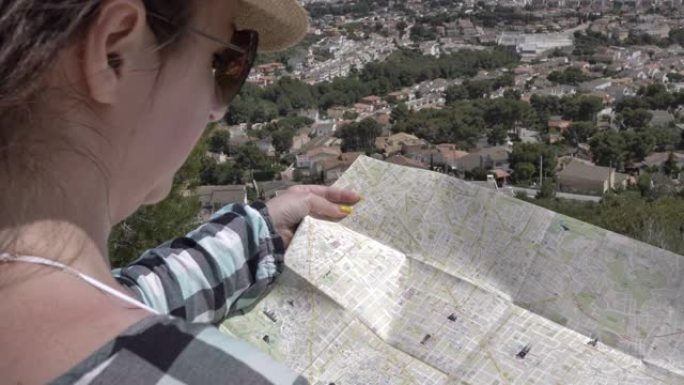 女人站在上面，看着城市地图，旅行概念
