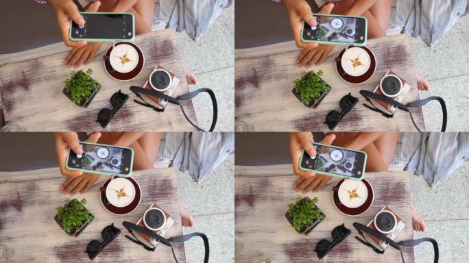 女性用一杯咖啡的智能手机拍照