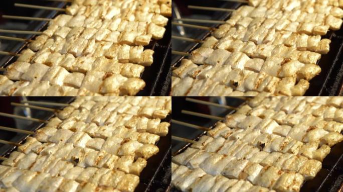 在热炉上烤的三文鱼串，泰国街头美食。
