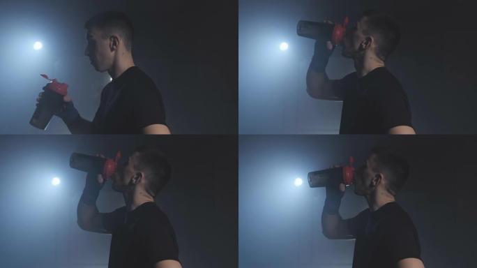 年轻的战士喝水。训练后，拳击手从瓶子里喝水