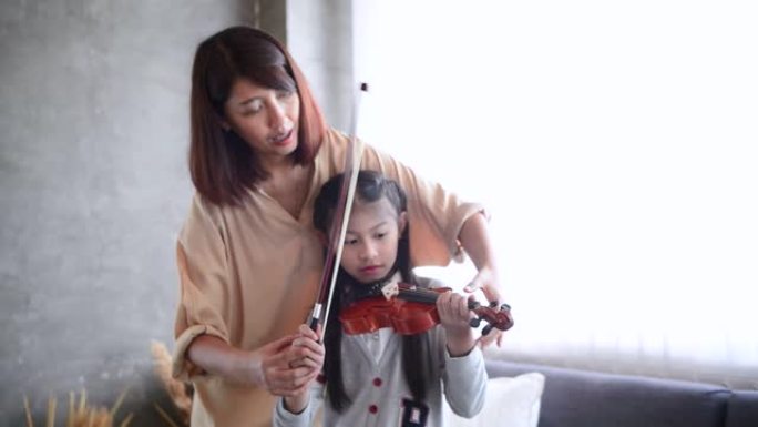 女人教小女孩如何拉小提琴