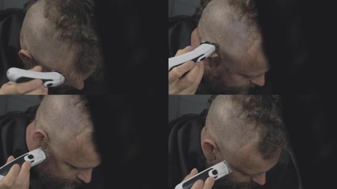 一个留着胡须的男人用电动修剪器剃头。大胡子朋克潮人剃毛了他的莫霍克族。男人剪头发。4k视频。59.9