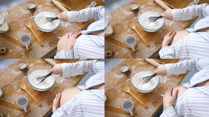 孕妇在厨房里做早餐时，在碗里搅拌牛奶的特写镜头。