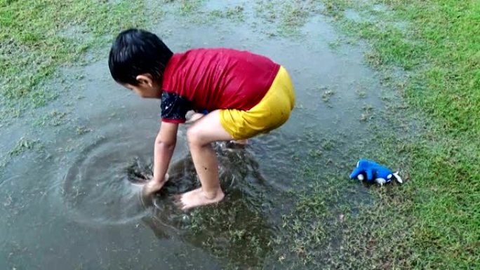 小学儿童在雨季在公园玩耍