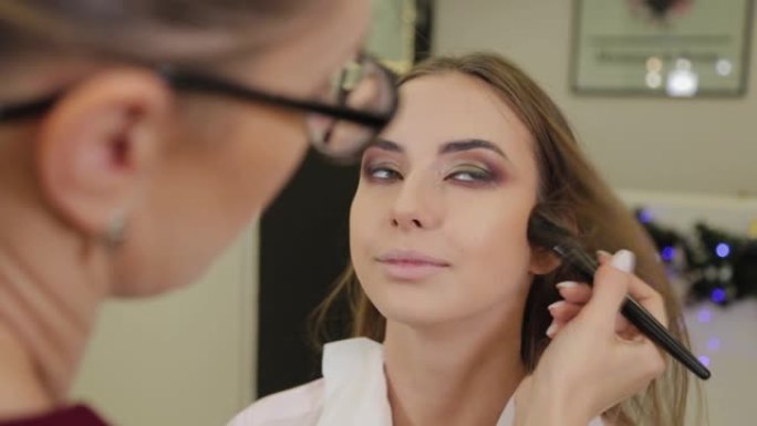 专业化妆师为美容院的客户戴上眼影