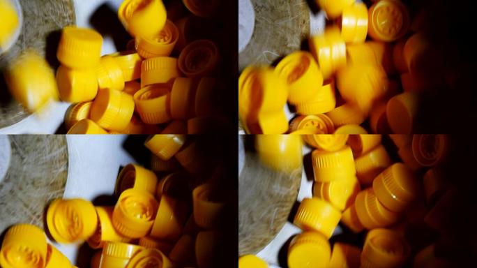 黄色塑料盖在向日葵油的传送带上旋转和掉落的原始视图