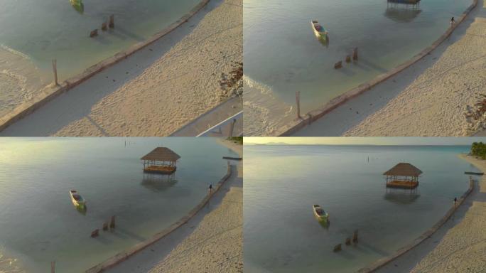 在菲律宾隐藏的热带岛屿上，妇女独自一人走到木制arbors的码头的航拍镜头
