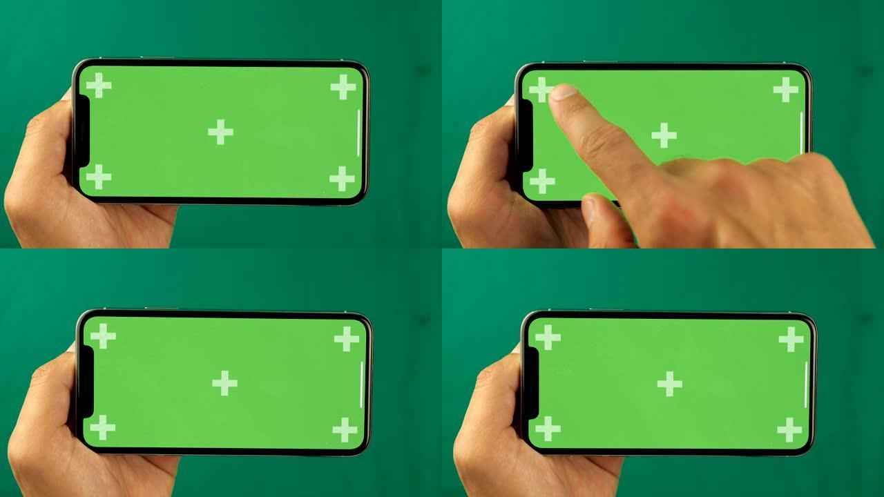 男性手触摸智能手机的特写。绿屏色度键。手机屏幕是绿色色度键，背景是另一个色度键绿色屏幕。移动广告素材