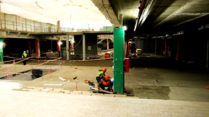 工人团体在商场大厅用湿水泥放置瓷砖