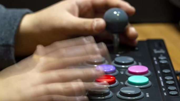 按下街机键盘的彩色按钮玩老式视频游戏的男孩
