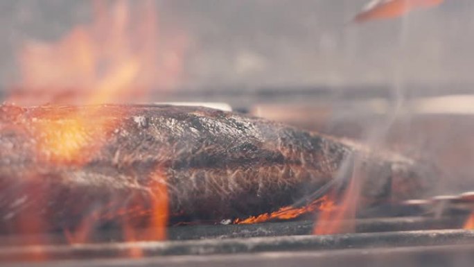 厨师把一块美味的肉放在烤架上。火在燃烧，多汁的牛排烹饪关闭慢动作。有机健康生活低脂火焰牛肉饼经典烧烤