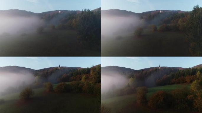 从无人机的角度来看，在一个有雾的早晨，在农村地区偏远的教堂
