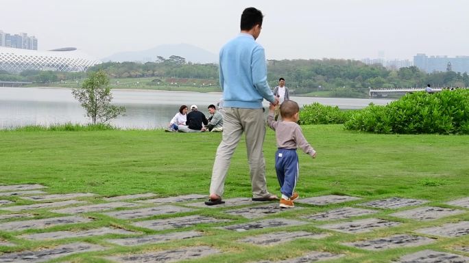父亲牵着孩子的手在公园散步升格视频