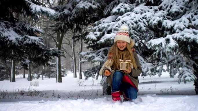 在降雪期间，小女孩将礼物送给了她在枞树附近的蓬松的柯基犬