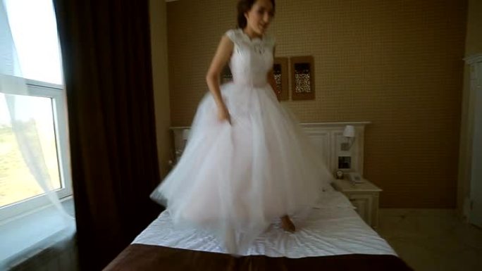 婚礼当天，开朗美丽的新娘在酒店房间的床上跳跃