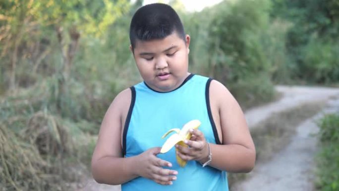 年轻的胖男孩从香蕉上剥了皮