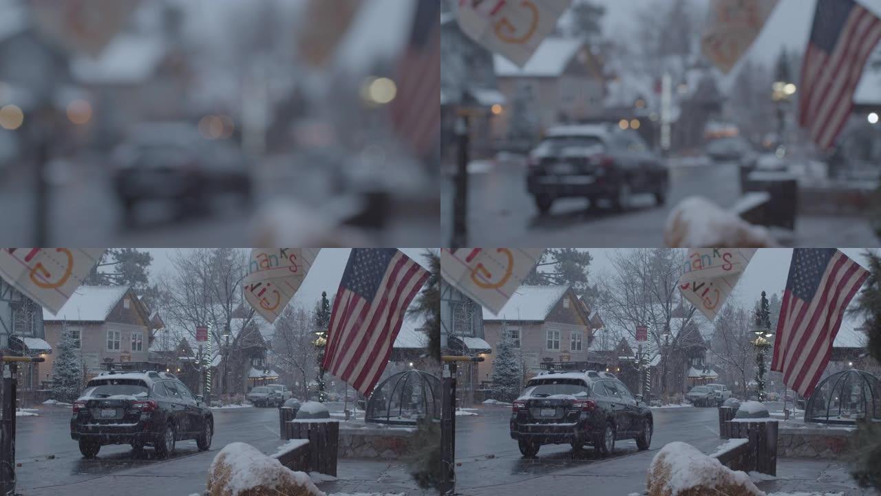 在积雪覆盖的圣诞节小镇上，一面美国国旗，人们步行和开车经过。