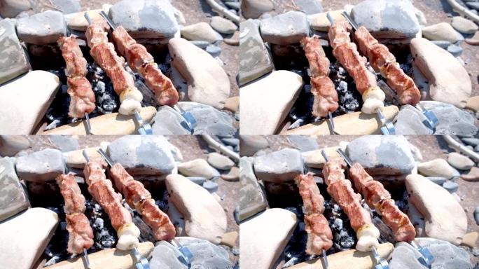 Shashlik在带有热炭的石头手工篝火上的串烧上烹饪。