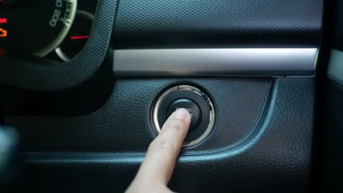 驾驶员按按钮启动汽车发动机的特写镜头。技术和运输概念。