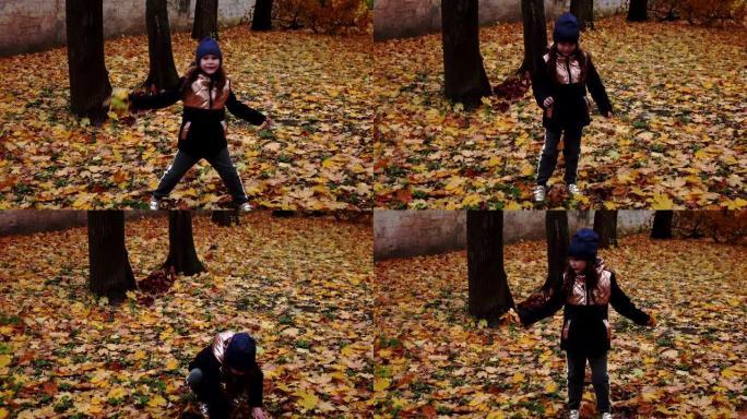 小女孩正在秋天的公园里玩树叶。