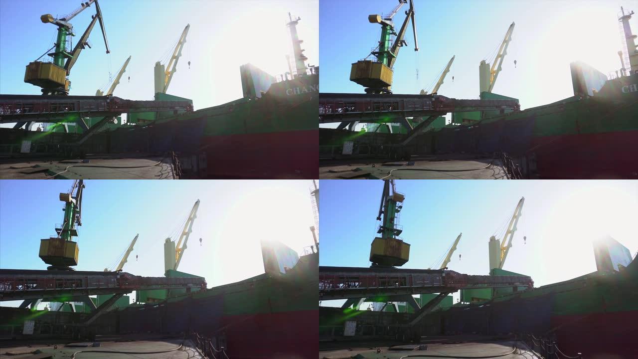 夏季，2019-纳霍德卡，滨海边疆区-总体规划。一艘货船站在装卸公司的系泊墙上。货运起重机将煤炭装载