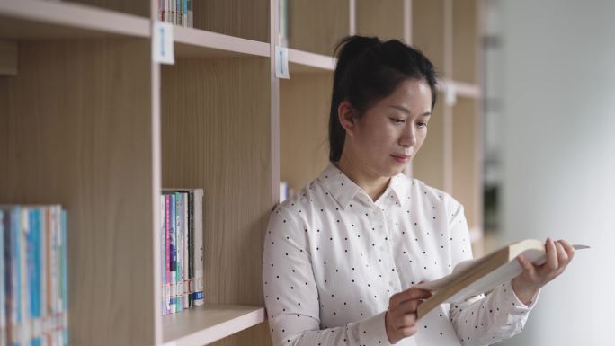 中年女性在图书馆学习阅读