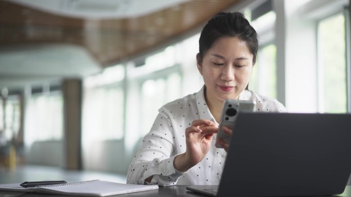 中年女性在办公室使用手机