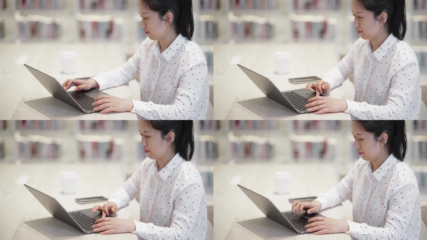 女性在图书使用笔记本电脑工作