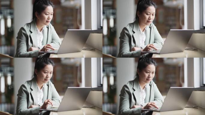 职业女性在图书使用笔记本电脑工作