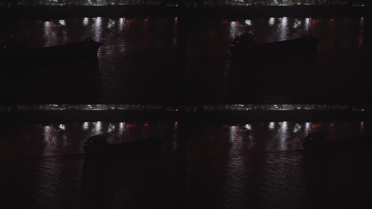 夜晚的城市江上行驶过一艘大型采砂船