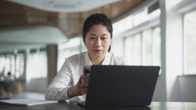 中年女性在办公室使用手机