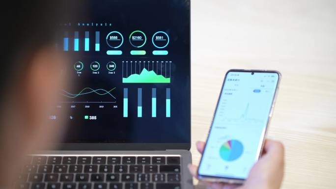 女性使用手机和笔记本电脑分析财务报告