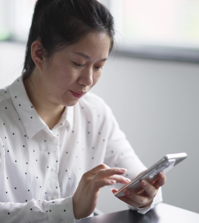 中年女性在办公室使用手机