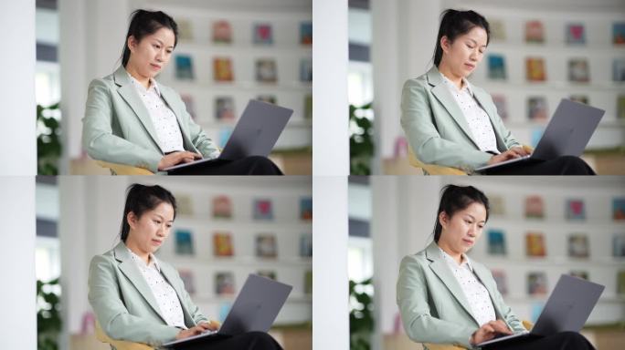 职业女性在图书使用笔记本电脑工作
