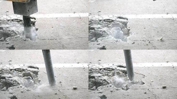 特写手提钻挖掘机在慢动作拍摄中钻孔混凝土地板。