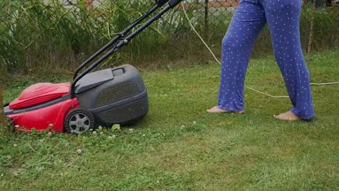 用电动割草机修剪草坪。
