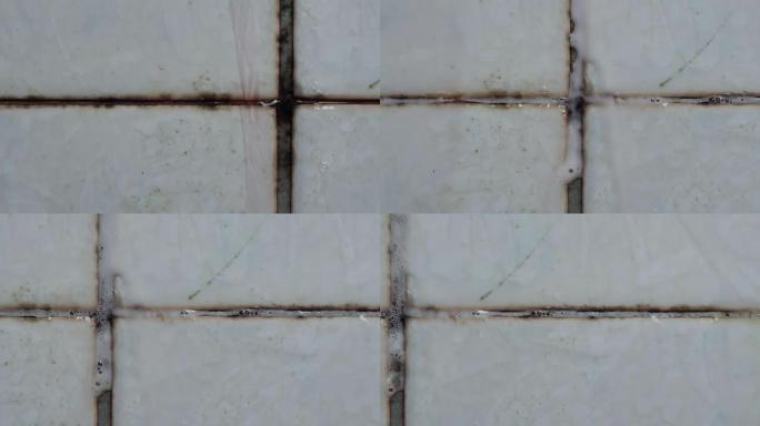 使用液体清洁剂清洁脏瓷砖墙的特写镜头，多莉镜头