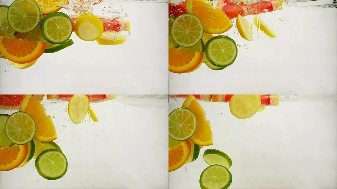 柑橘类酸橙，柠檬，橙子，葡萄柚片落入水中，带有飞溅和气泡，慢动作特写
