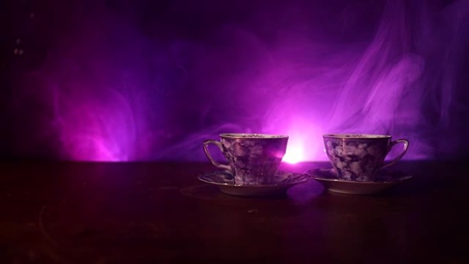 咖啡或茶道概念主题。老式陶瓷茶或咖啡壶，带杯壶和糖杯，背景为深色，光线和烟雾。文本的空白。滑块镜头
