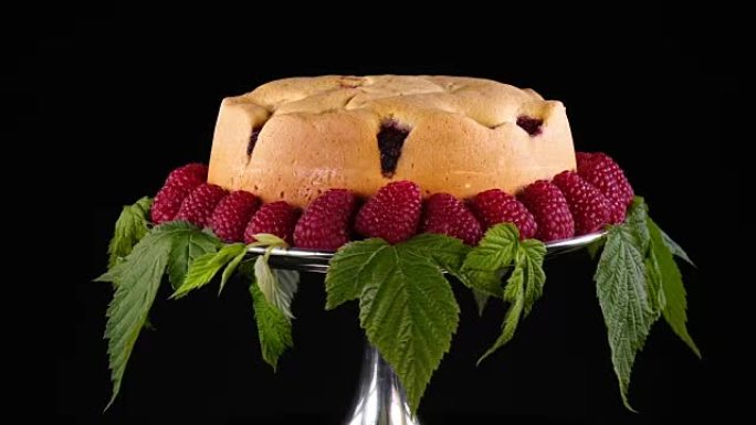自制饼干，覆盆子放在银蛋糕架上，并由新鲜浆果和叶子装饰。