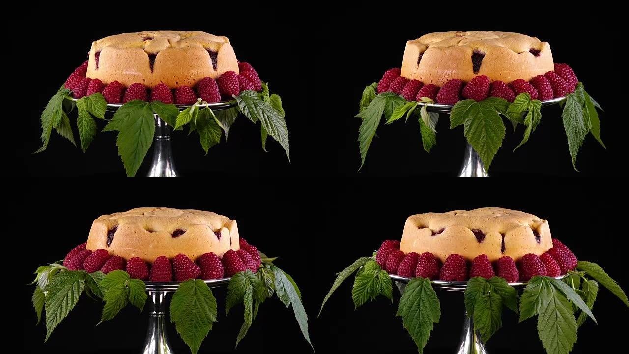 自制饼干，覆盆子放在银蛋糕架上，并由新鲜浆果和叶子装饰。