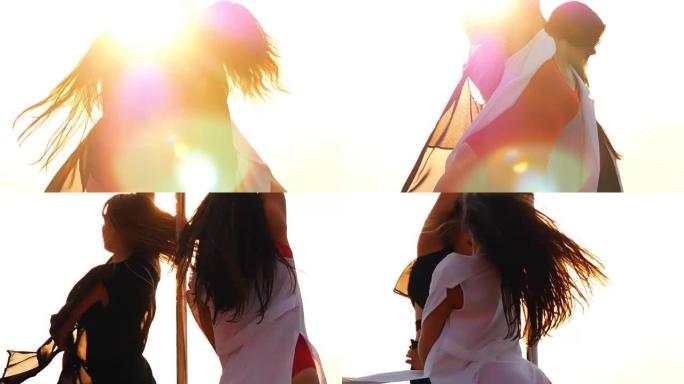 两名年轻女子在户外日落时表演钢管舞