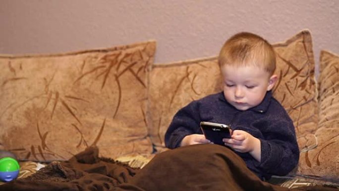 小男孩在智能手机上玩游戏