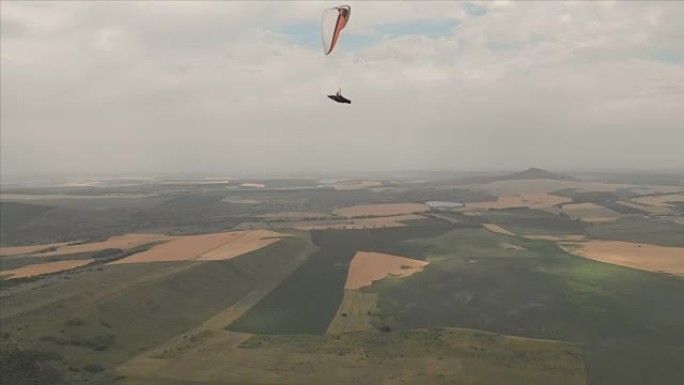 运动员滑翔伞在燕子旁边的滑翔伞上飞行。无人机的后续拍摄